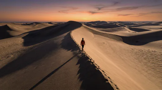 KI-generiertes Moodbild: Wanderer auf Sanddüne aus der Drohnenperspektive