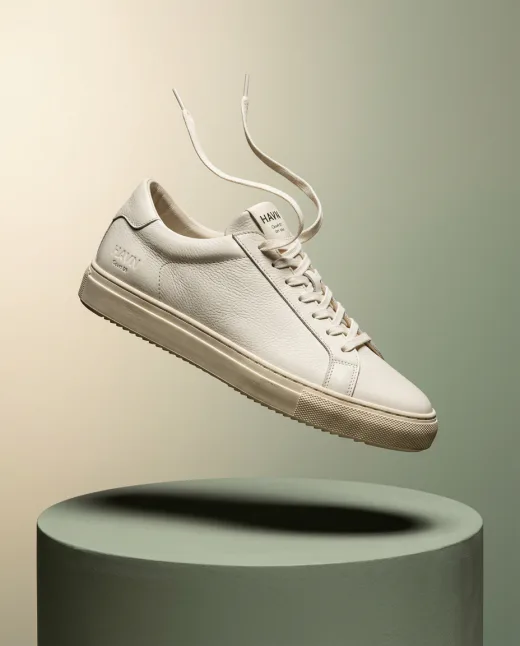 KI-generiertes Produktbild: schwebender Leder-Sneaker über Podest